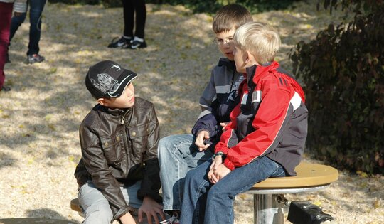 BA.052.-Kinder-sitzen-auf-Balancierschule-holz_metall.JPG