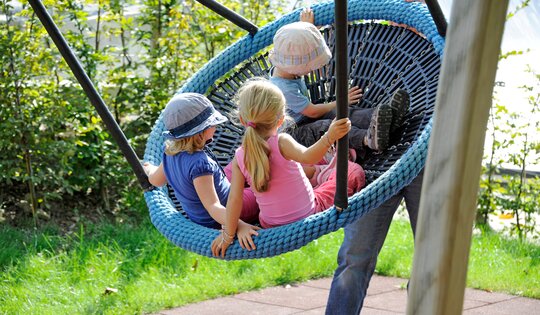 SC.080.3-Nestschaukel-Holz-Metall-classic-mit-Kindern.jpg